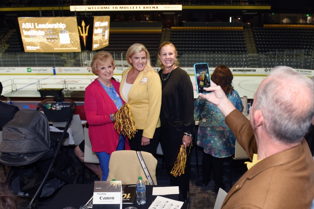 Group of event attendees pose for a photo at Mullett Arena.