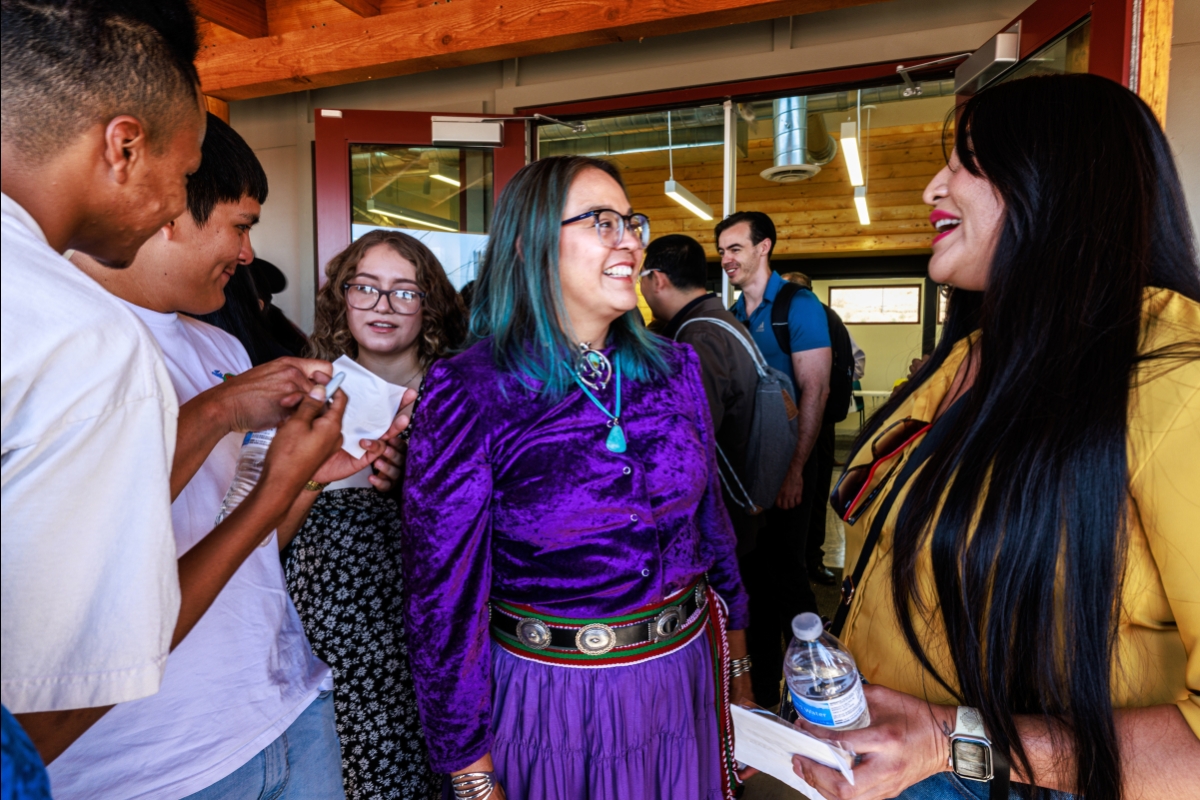 Woman talking to members of the community during grand opening event