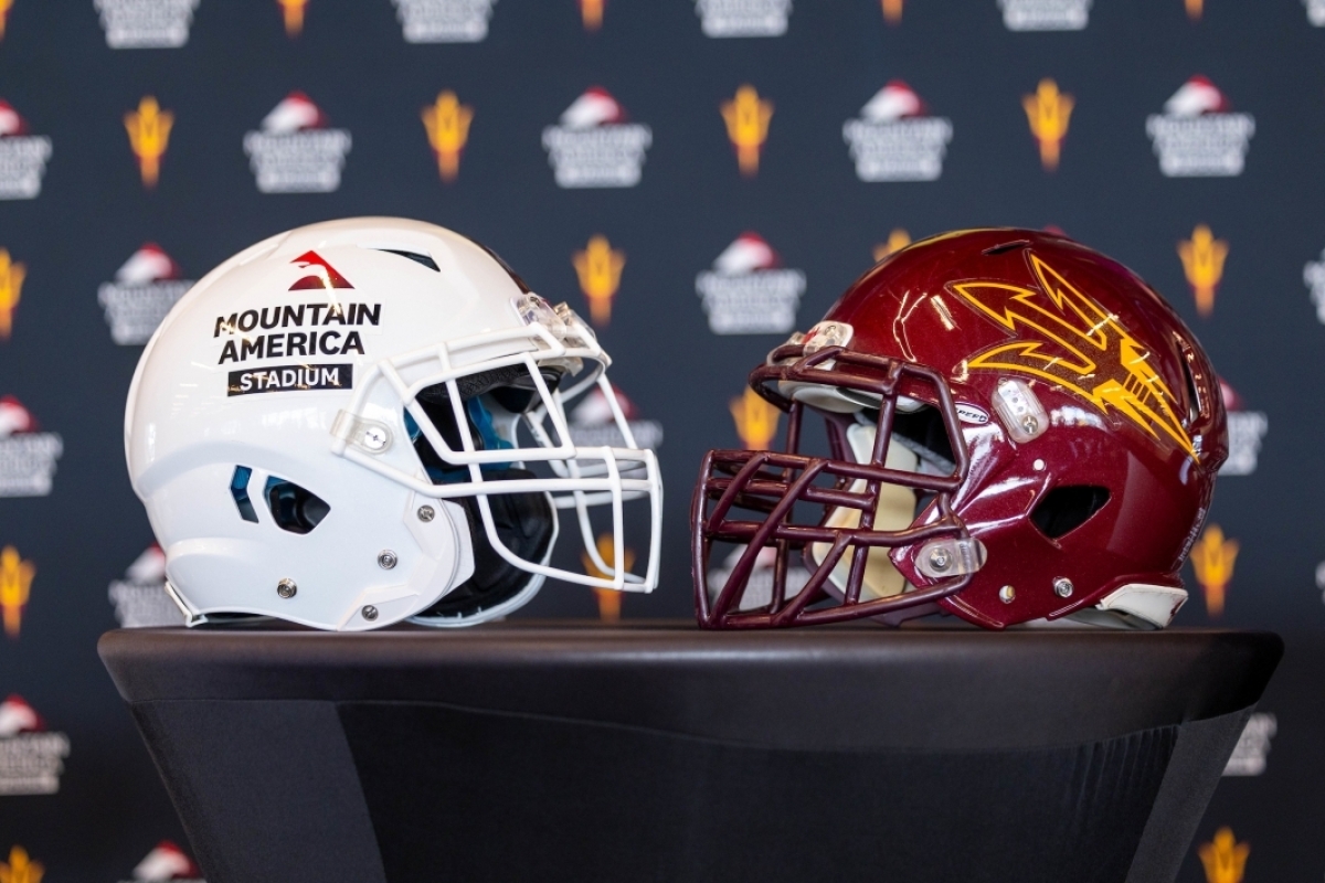 An ASU pitchfork football helmet sits next to a helmet with the wording Mountain America Stadium.