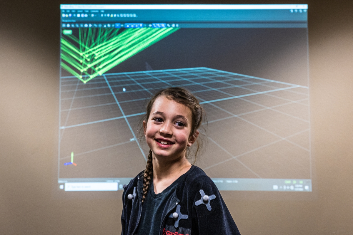 Young girl in front of screen displaying line data