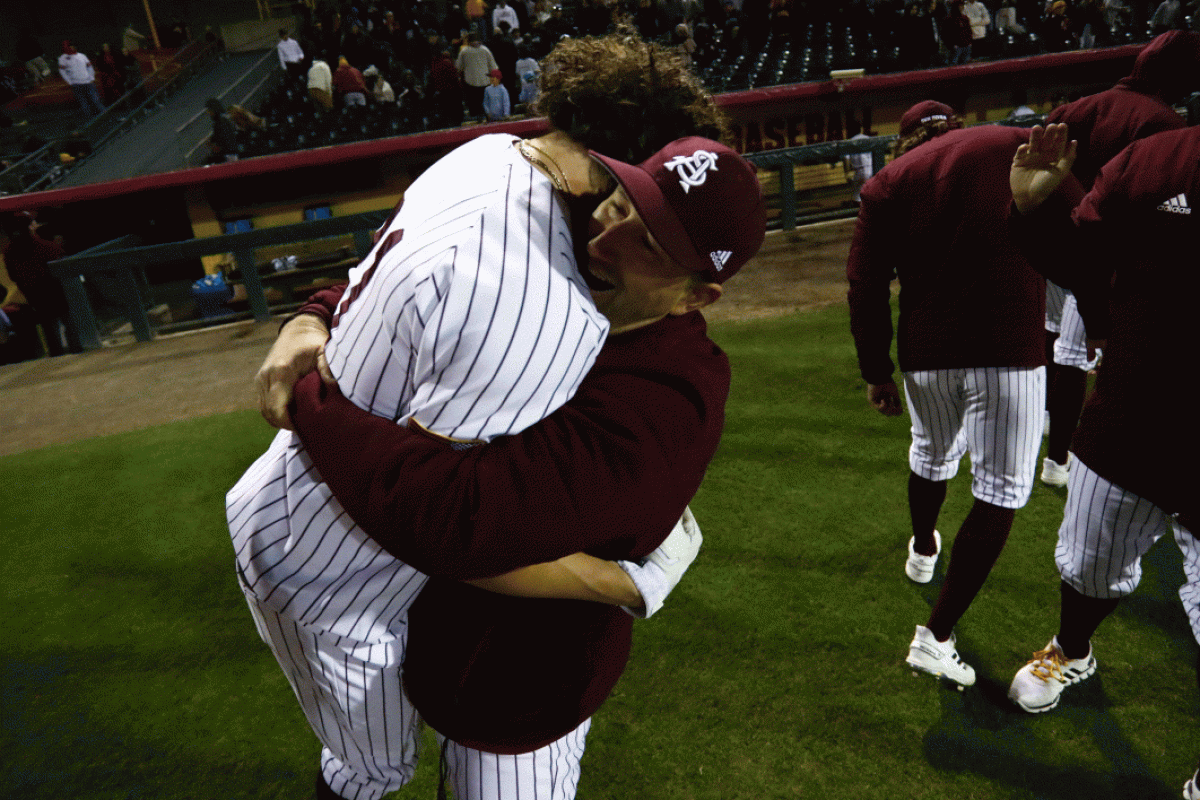 Coach hugging baseball player