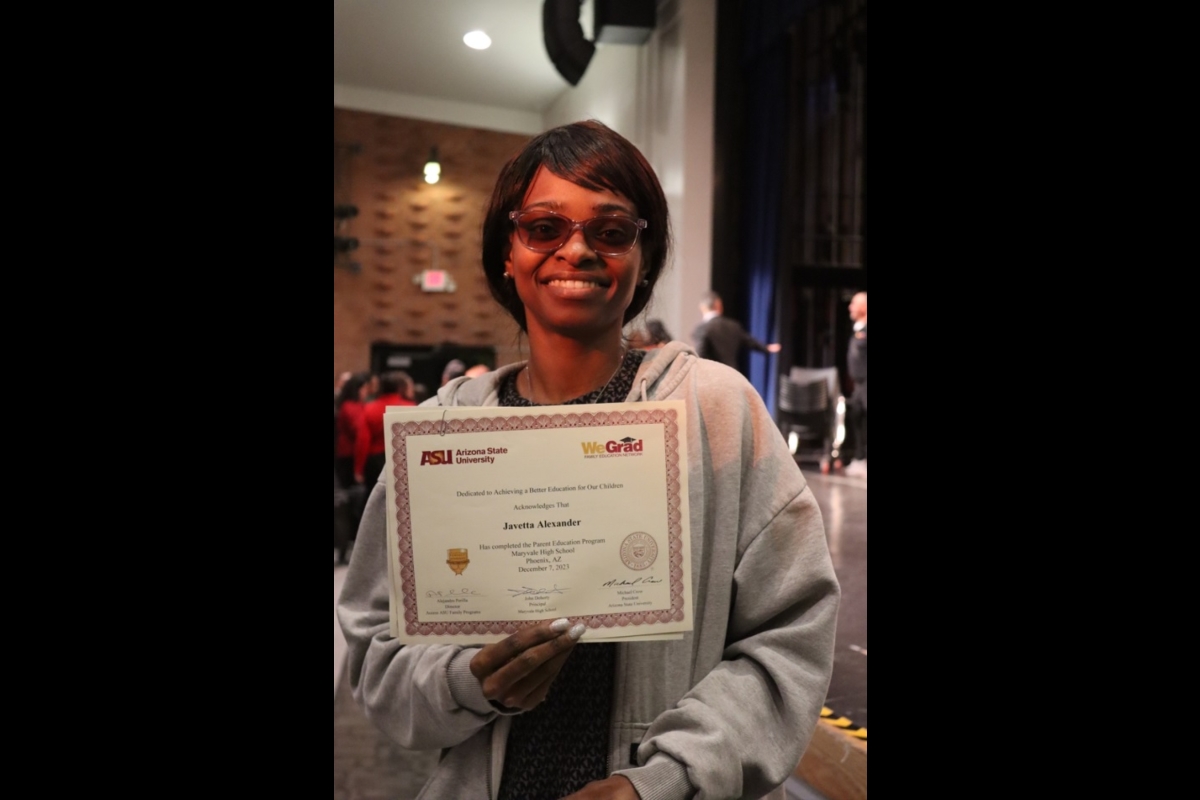 Woman holding a certificate and smiling.