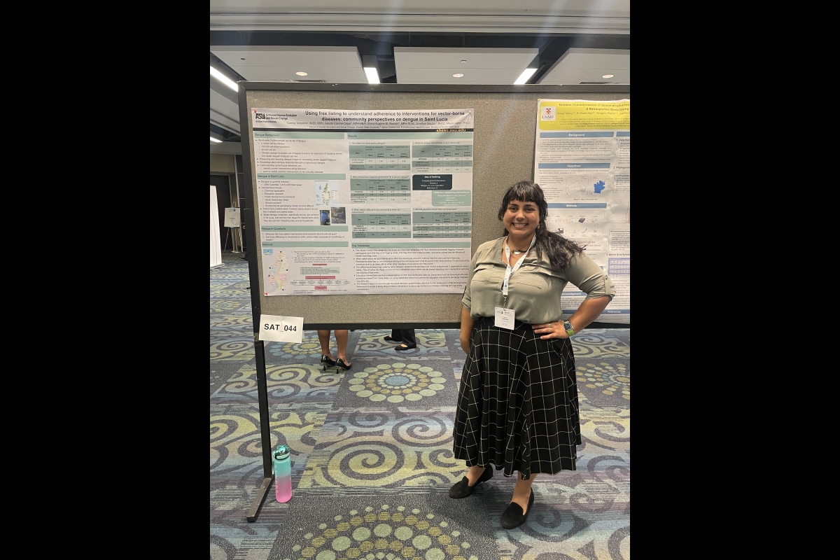 Woman standing next to a research poster.