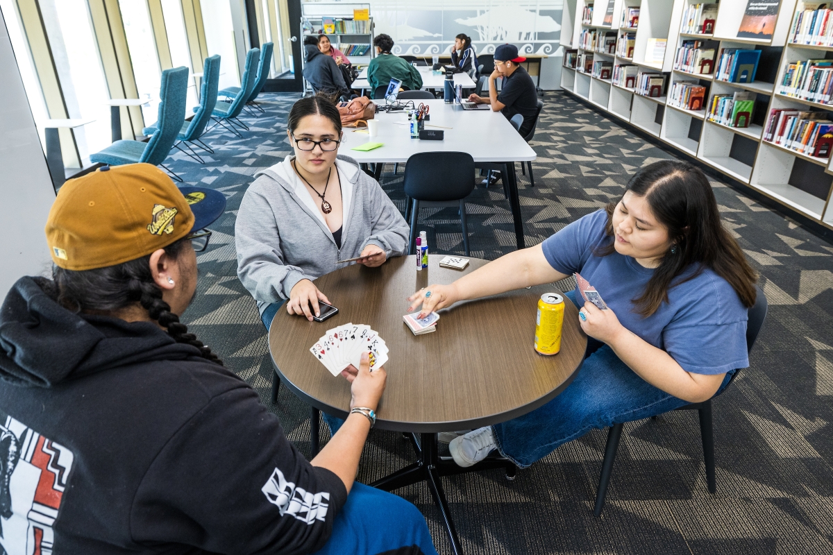 Students playing cards at a round table