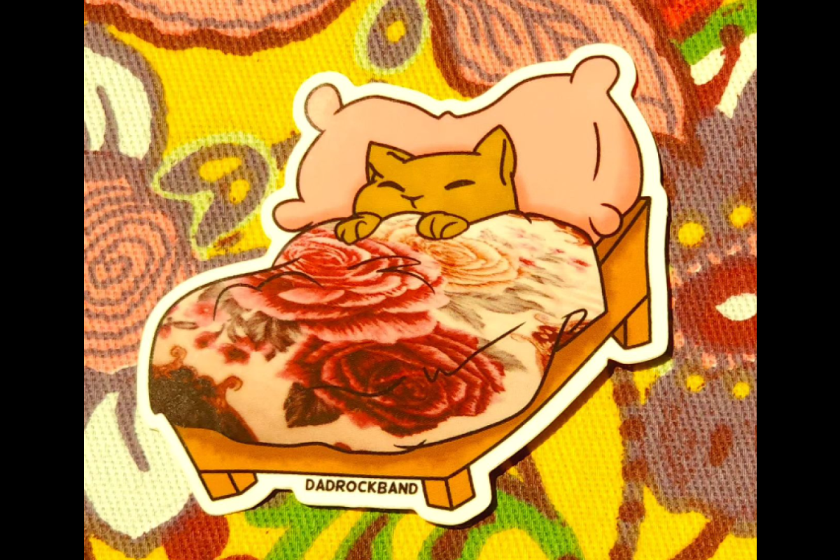 Sticker of a cartoon cat in bed