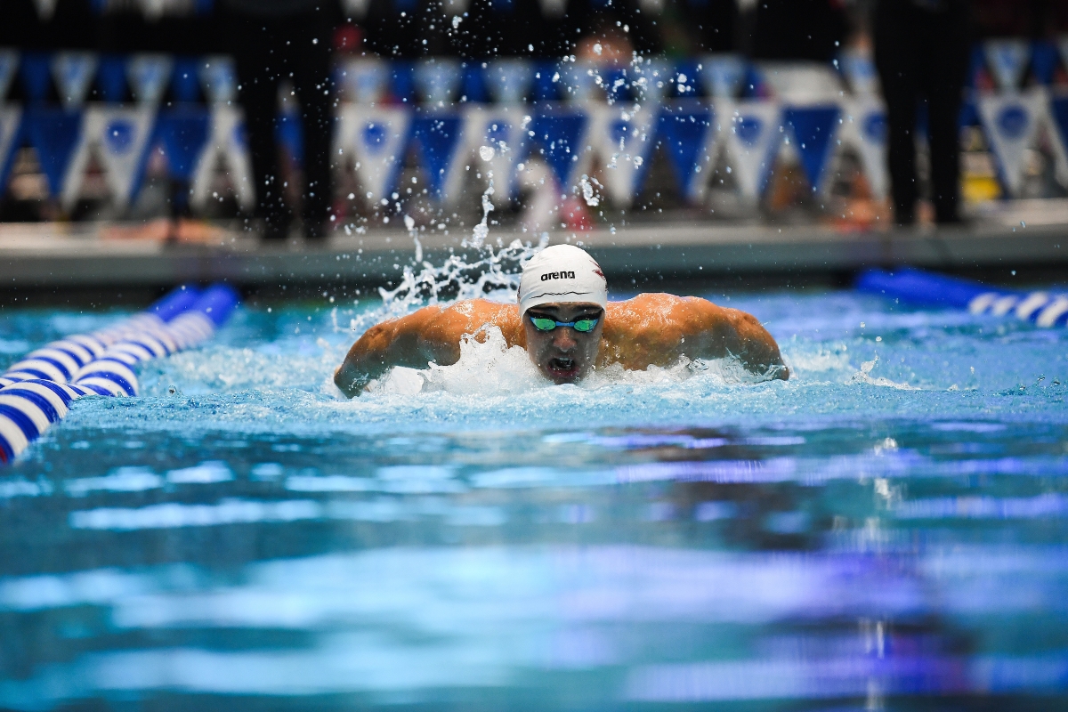 A male swimmer moves down a lane at a pool