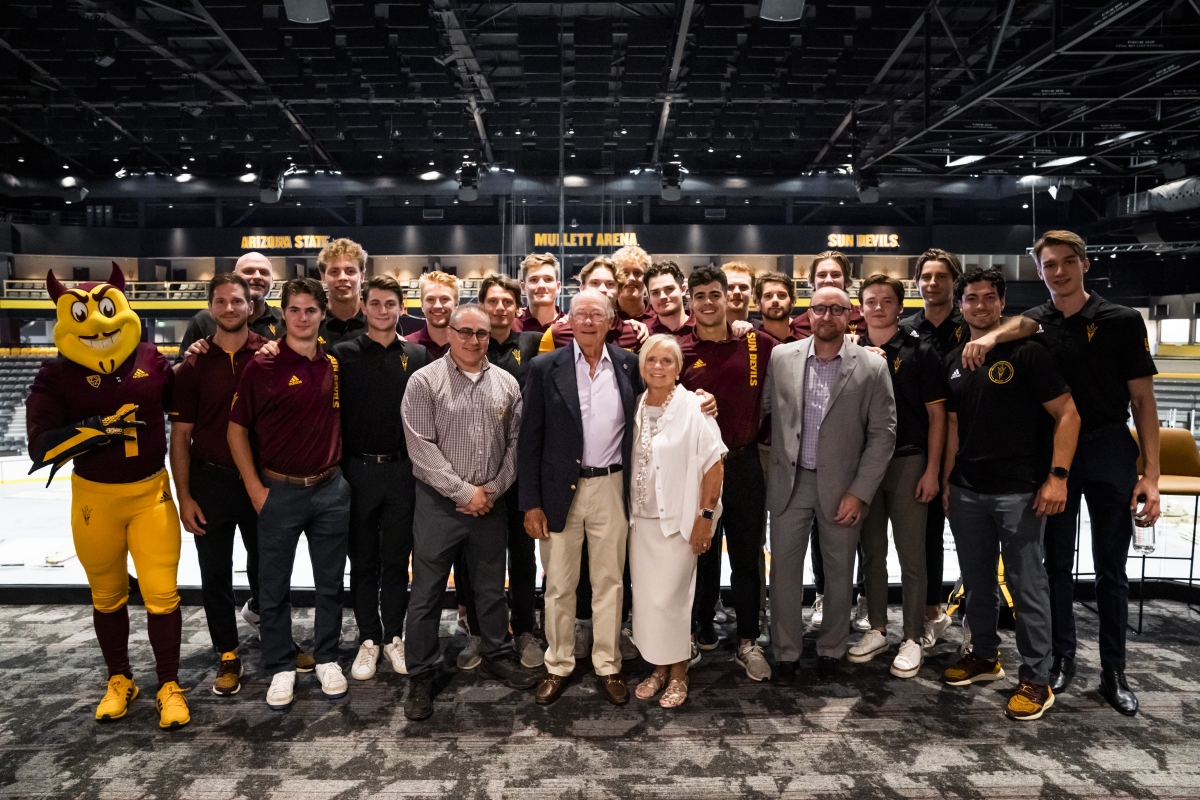 Don and Barbara Mullett stand with Sparky and the Sun Devil Hockey team near the Mullett Arena ice rink