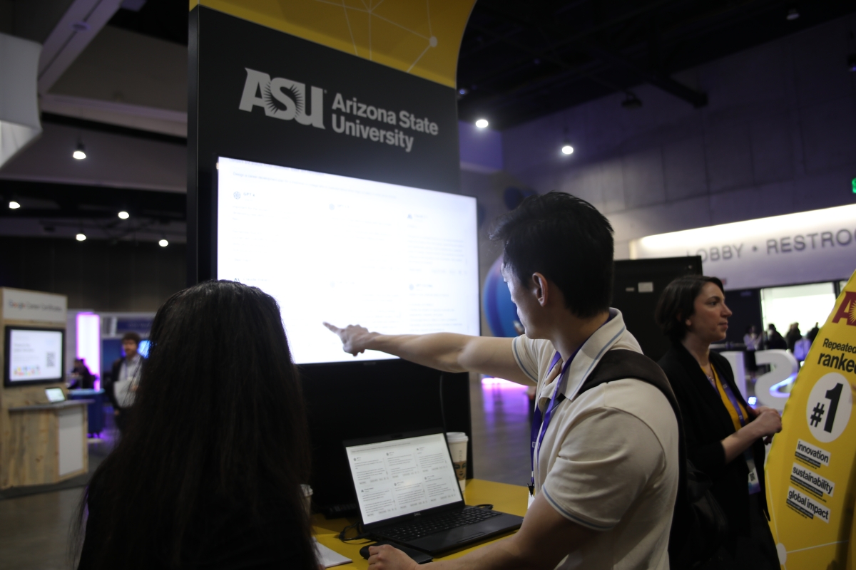 People interacting with screen at ASU booth