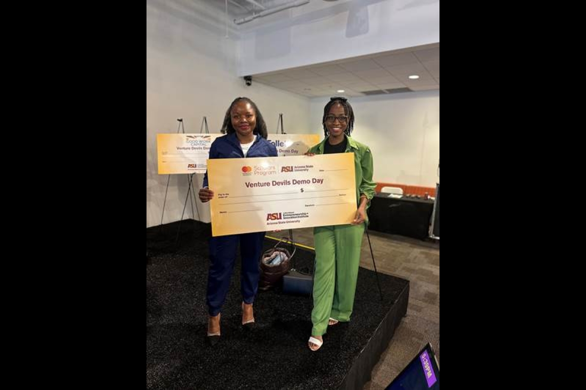 Two women holding giant check