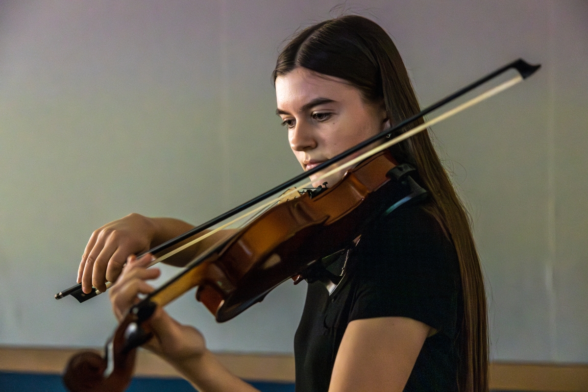 Female student plays her violin at the Guns Art-making and Truth event