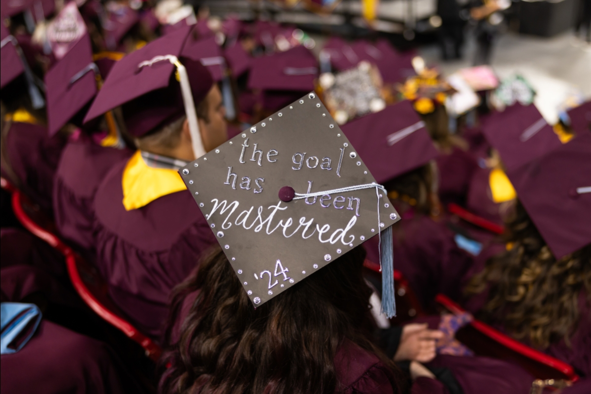 Graduate wearing cap that says: The goal has been mastered