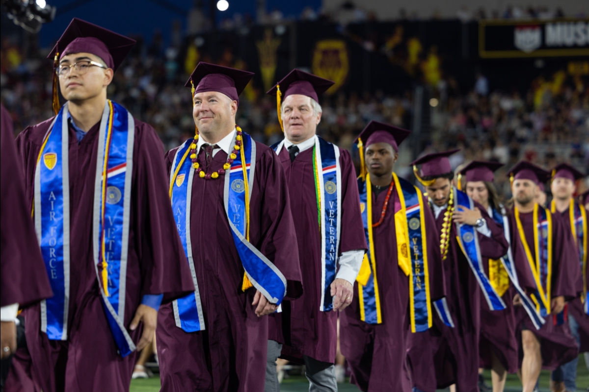 ASU graduates wearing blue veteran stoles walk into ceremony