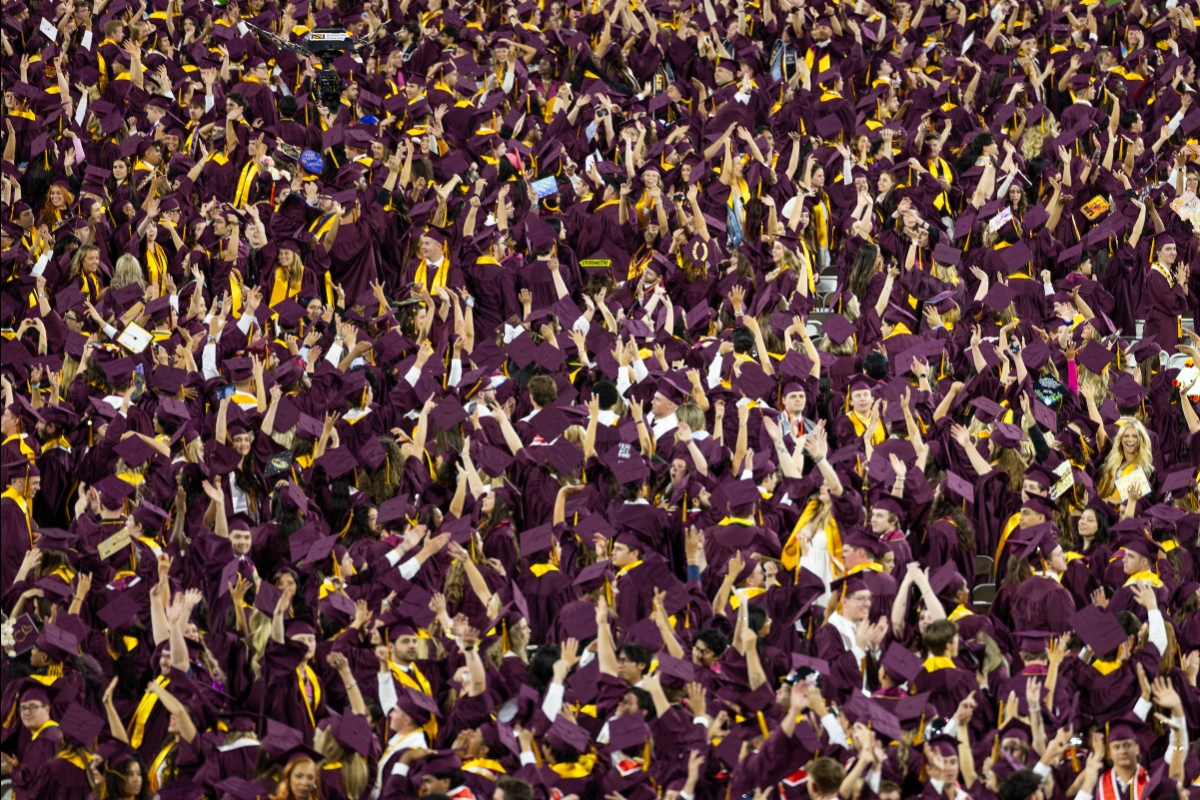 A sea of graduates in maroon and gold during commencement