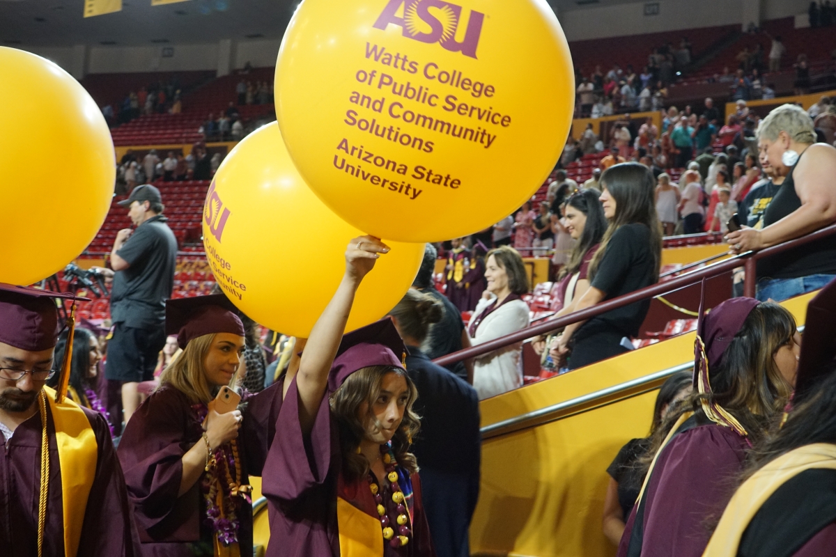 Graduates carry out balloons as they exit the arena