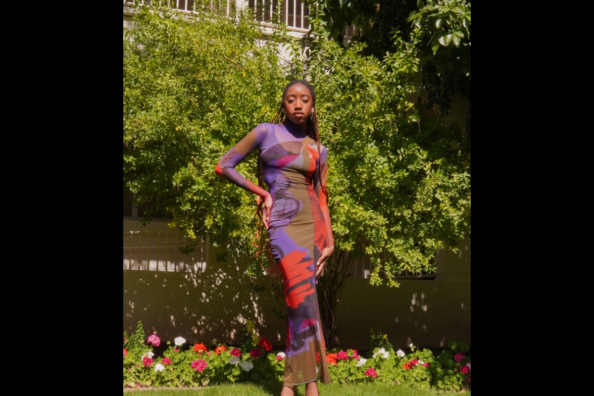 A woman modeling a colorful maxi dress in an outdoor setting.