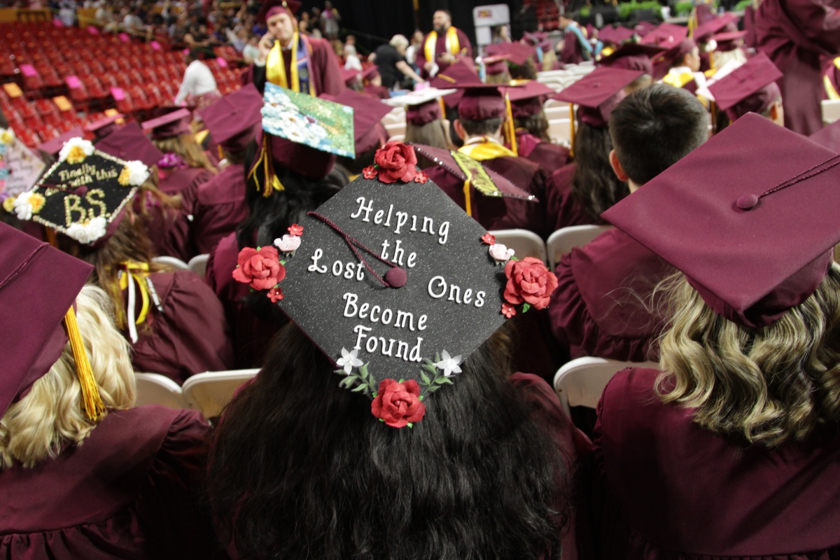 A graduate's mortarboard is decorated with a message reading 
