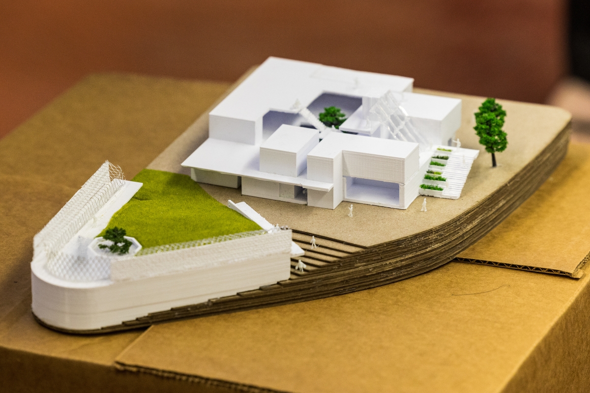 A three-dimensional model of a building sits on a tabletop