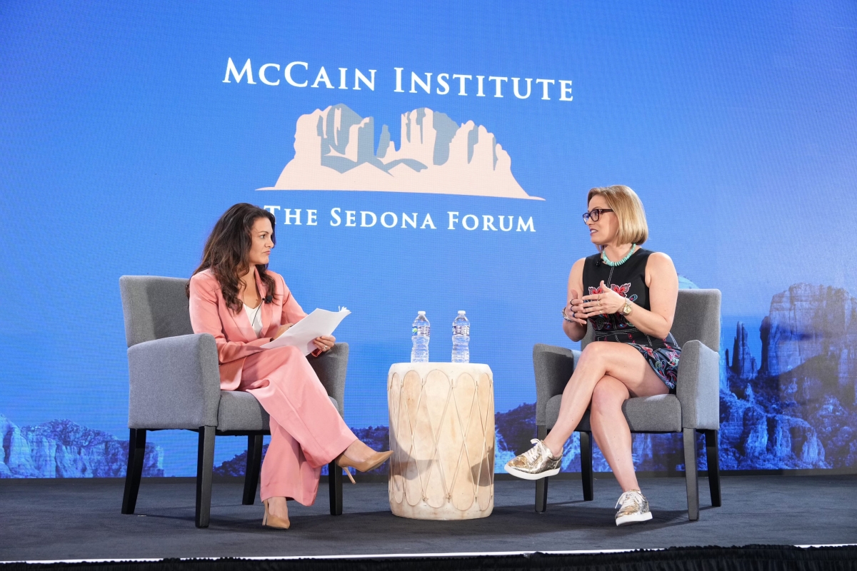 Arizona Sen. Krysten Sinema speaks with a moderator on stage during a McCain Institute event