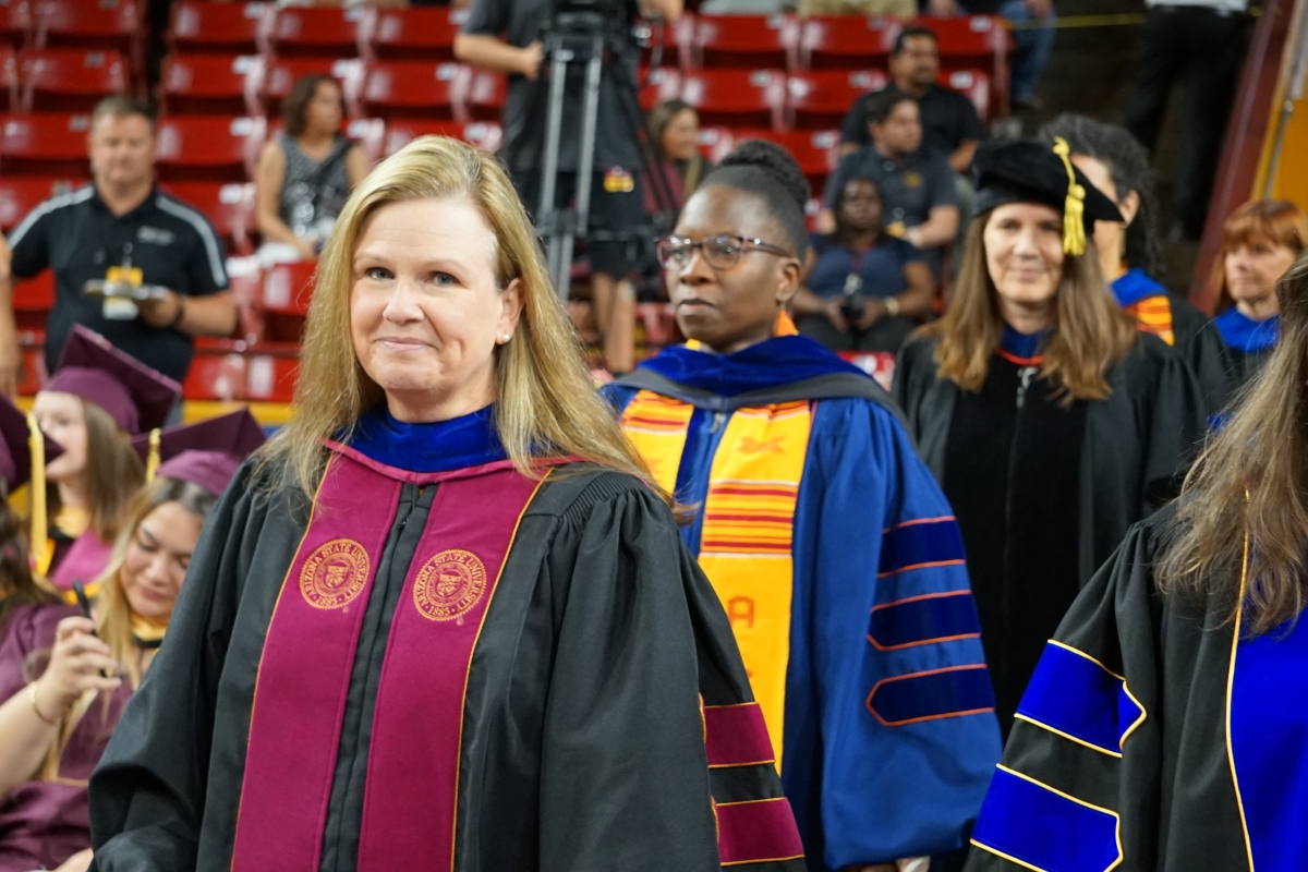 Dean Cynthia Lietz stands in a line of others dressed in graduation regalia.