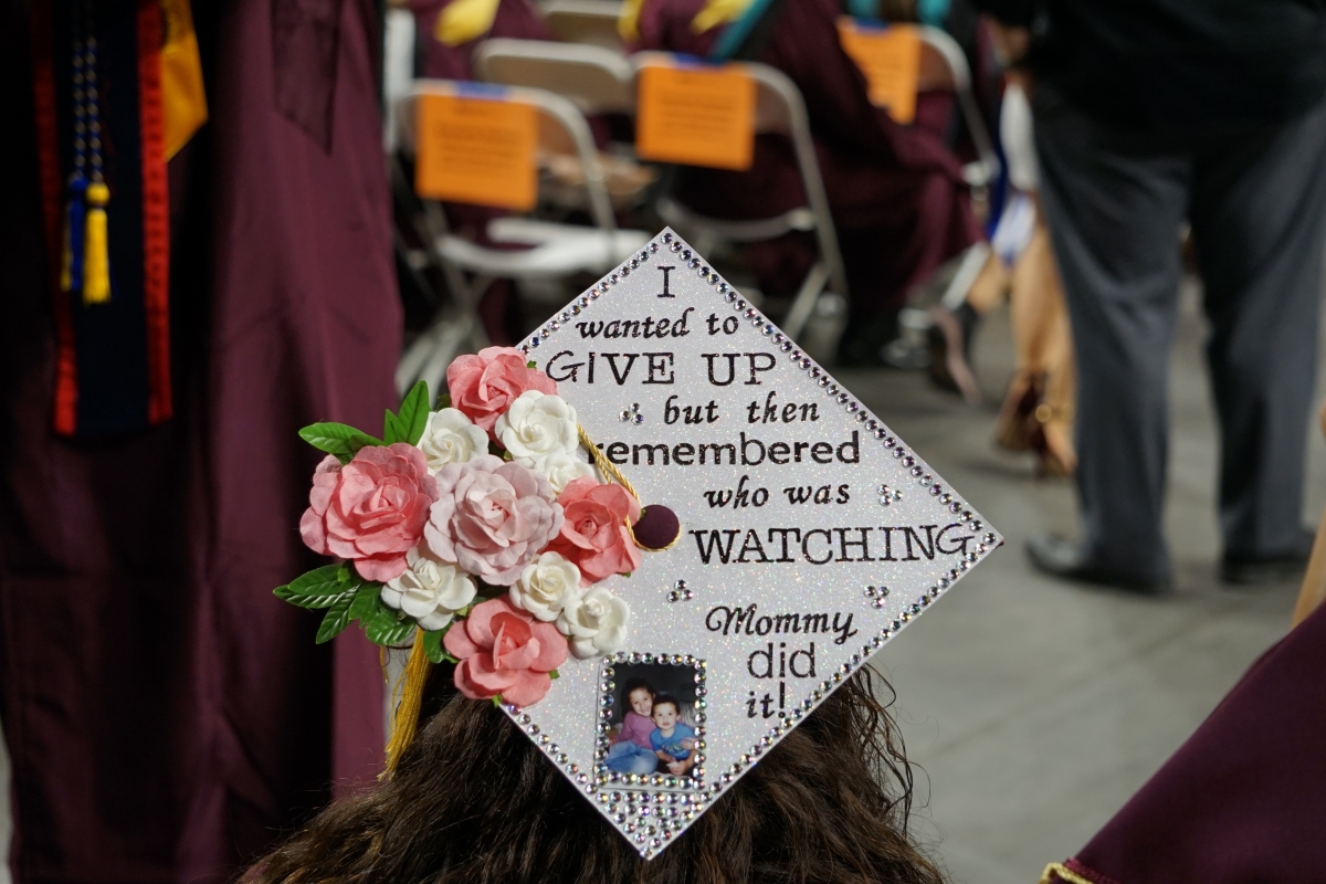 A graduate's mortarboard is decorated with a message reading 