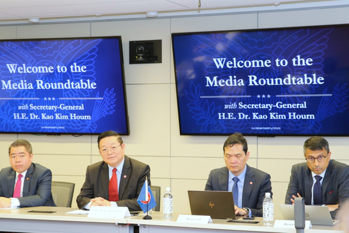 Kao Kim Hourn and three other men sitting in front of a backdrop reading 