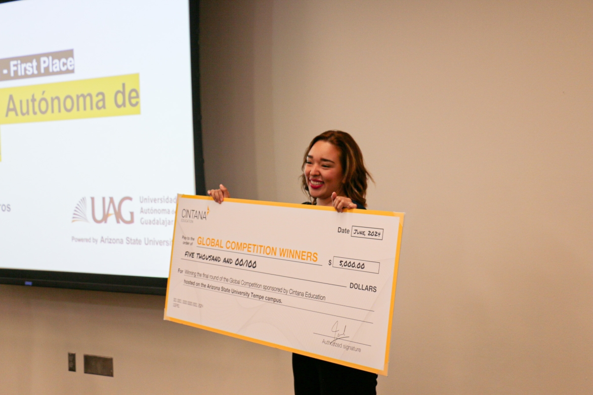 Woman holding a large novelty check and smiling.
