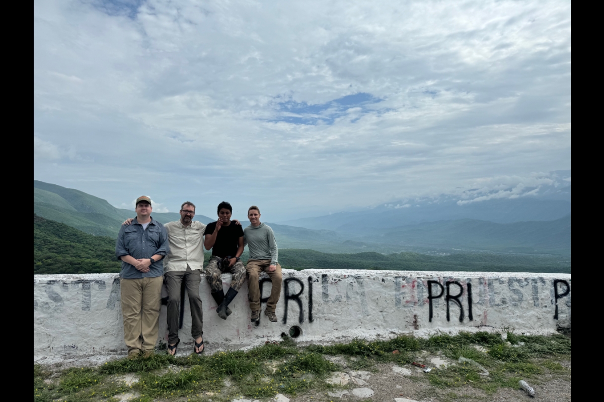 Four men from research team sitting on a wall in Mexico