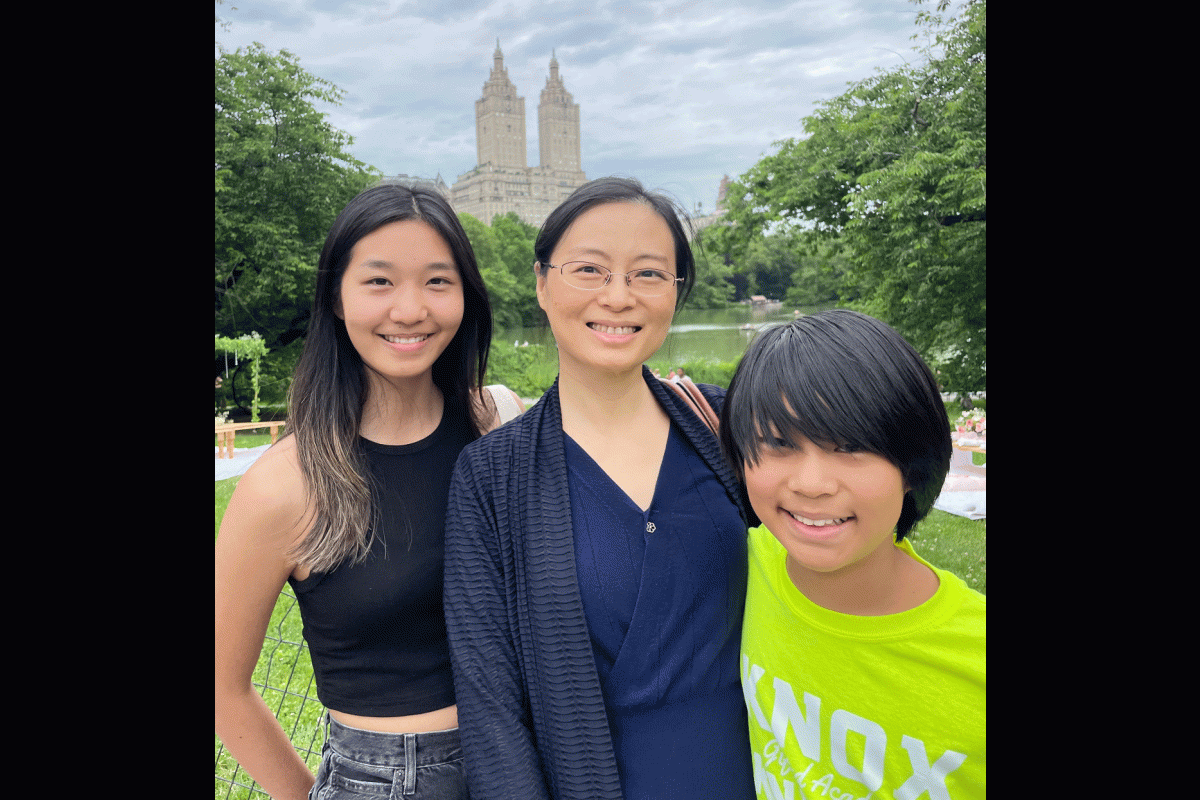 A mom poses for a photo with her children