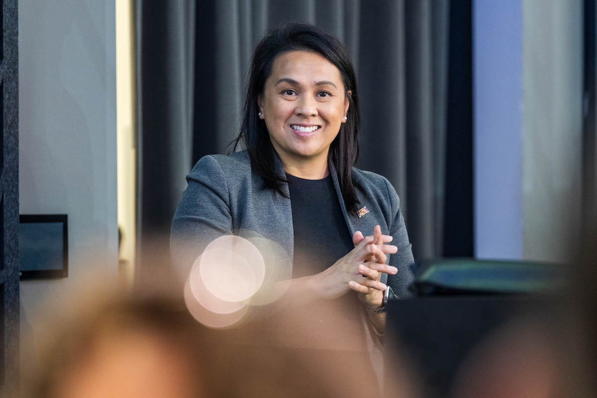 Close-up of a woman behind a lectern speaking to the audience