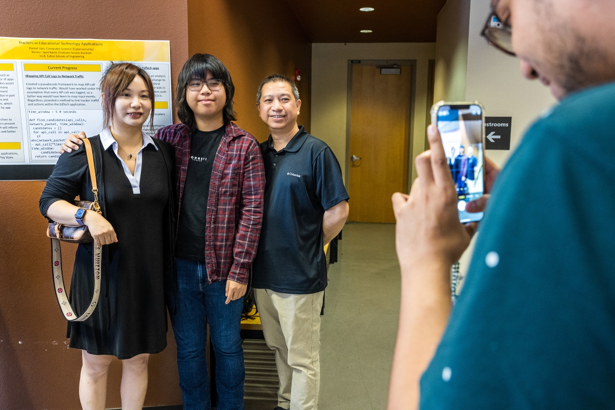 High school student posing with mom and dad for a photo