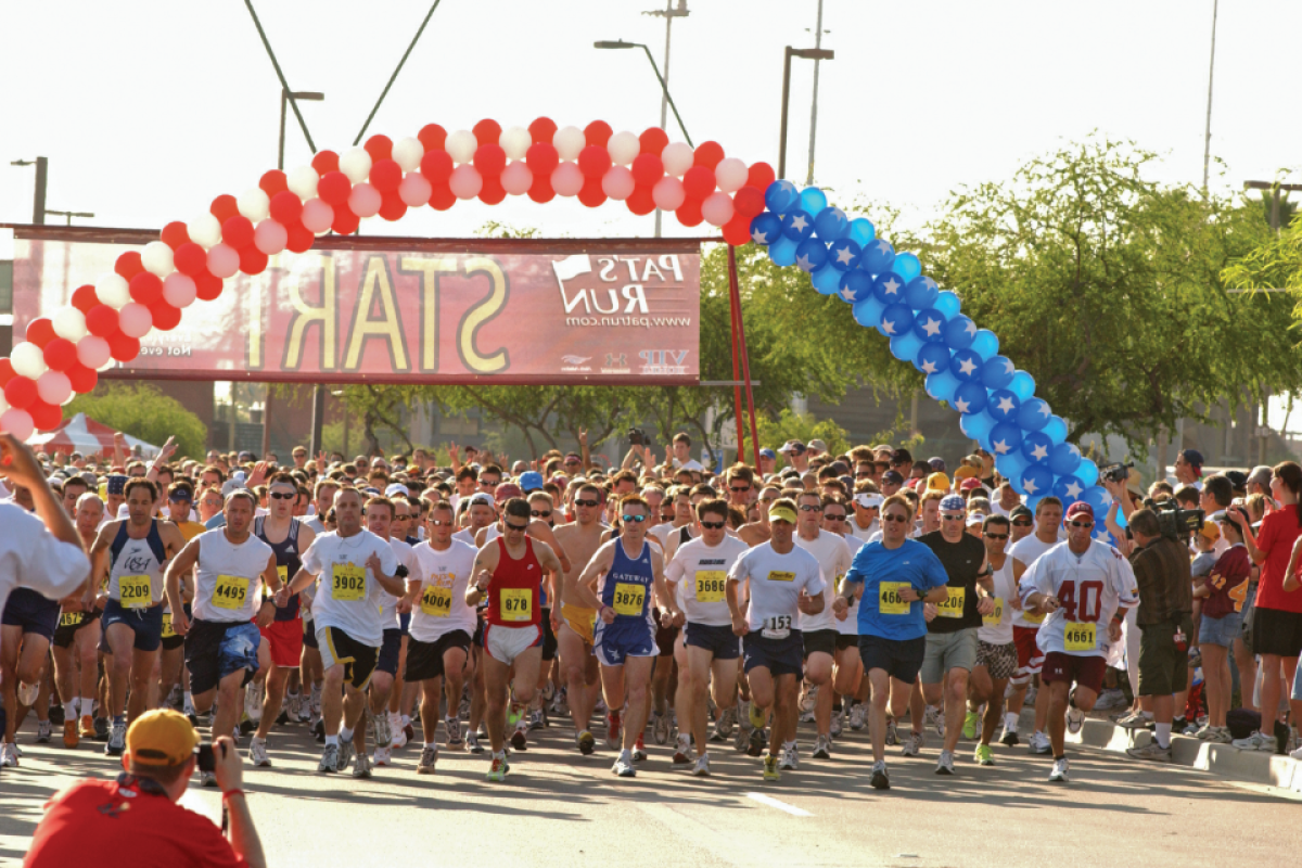 People starting race under blue and white balloons