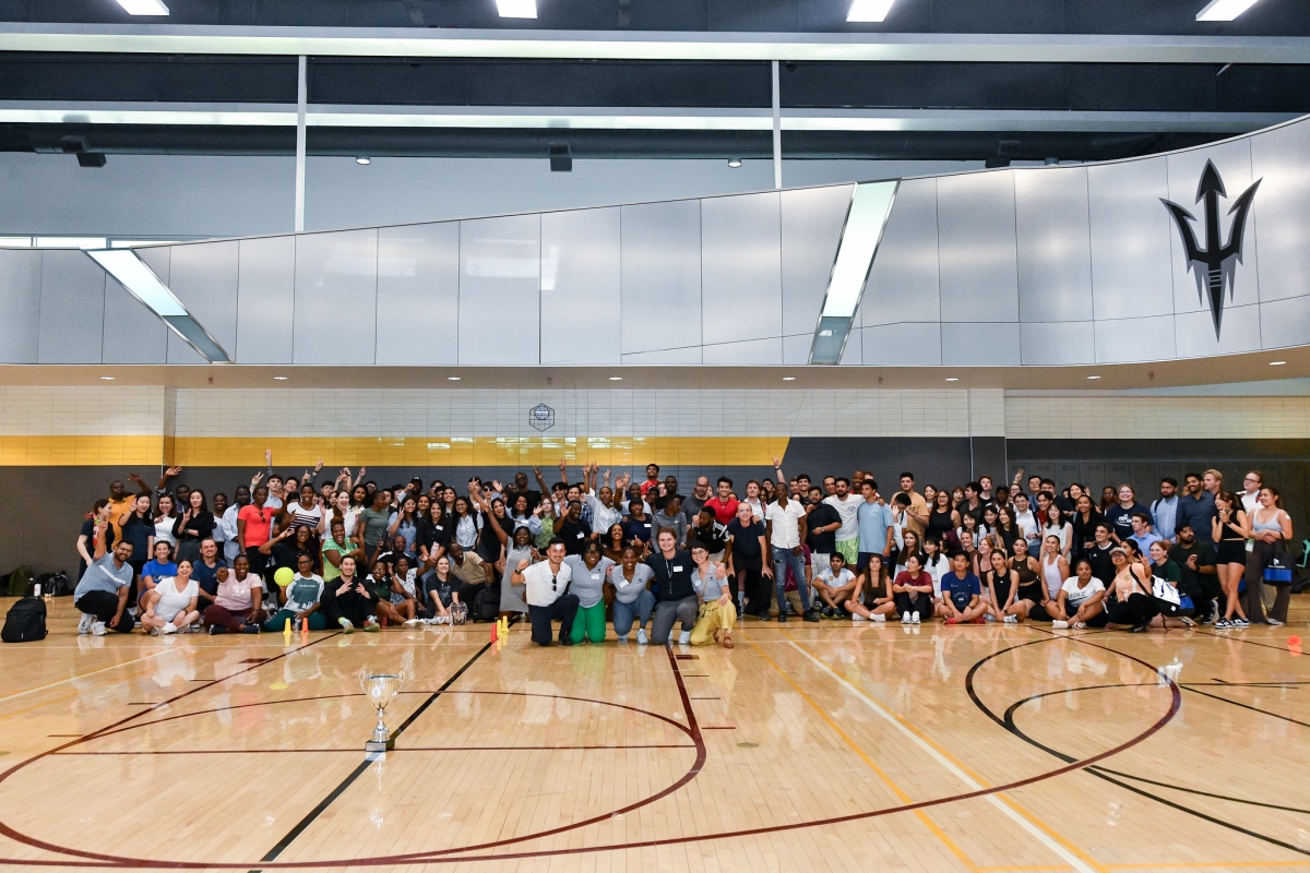 People gathered in a gymnasium for a group photo.