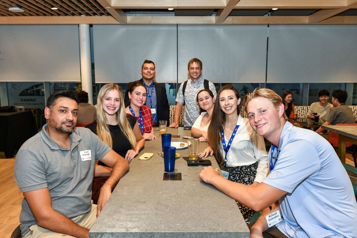 Students seated at a long table socializing.