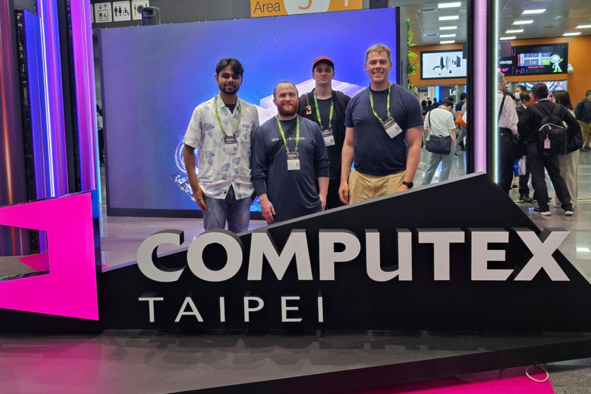 Four students pose in front of the COMPUTEX Taipei sign.