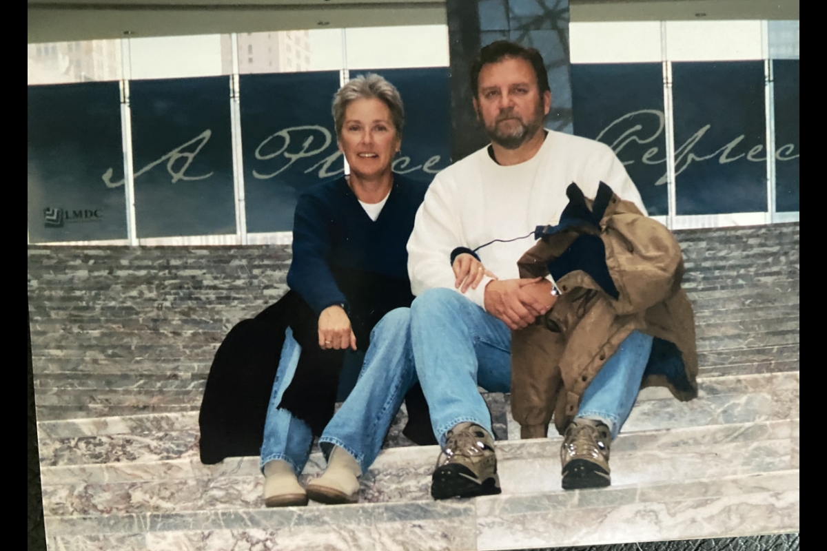 Man and woman seated closely on stairs.