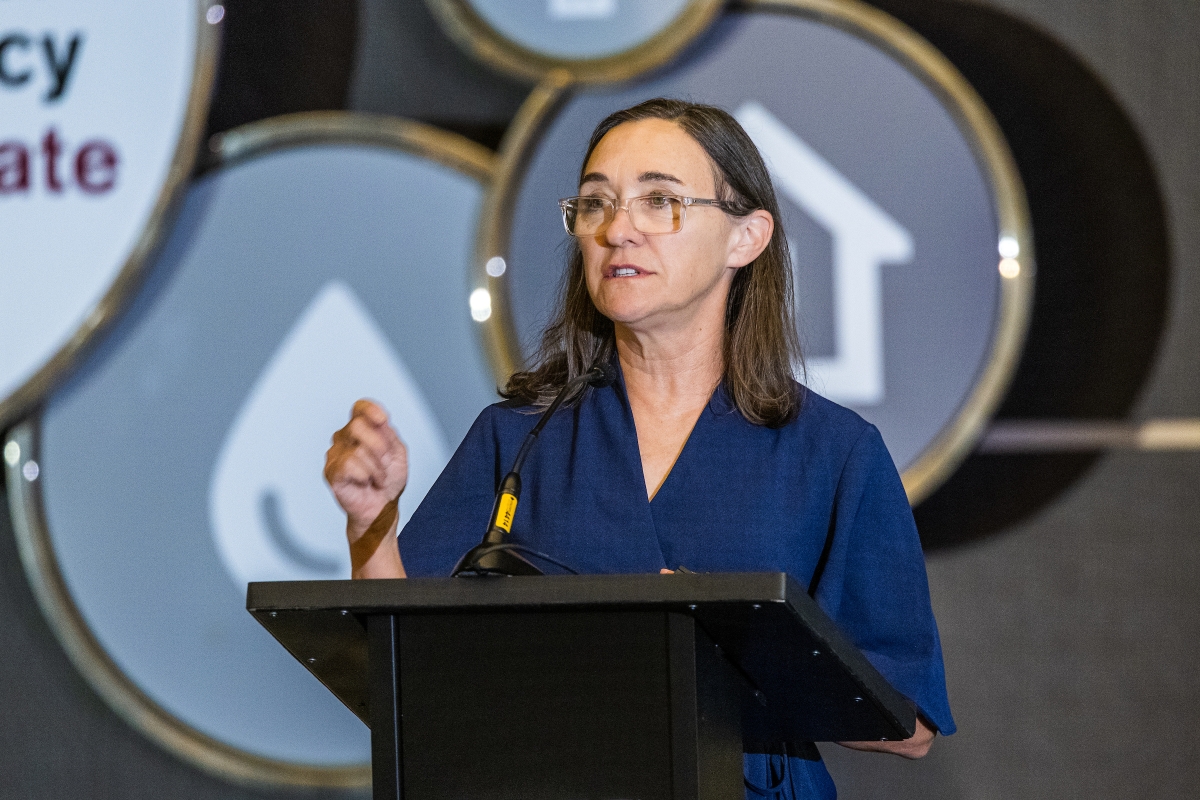 Woman in glasses speaks behind a lectern.