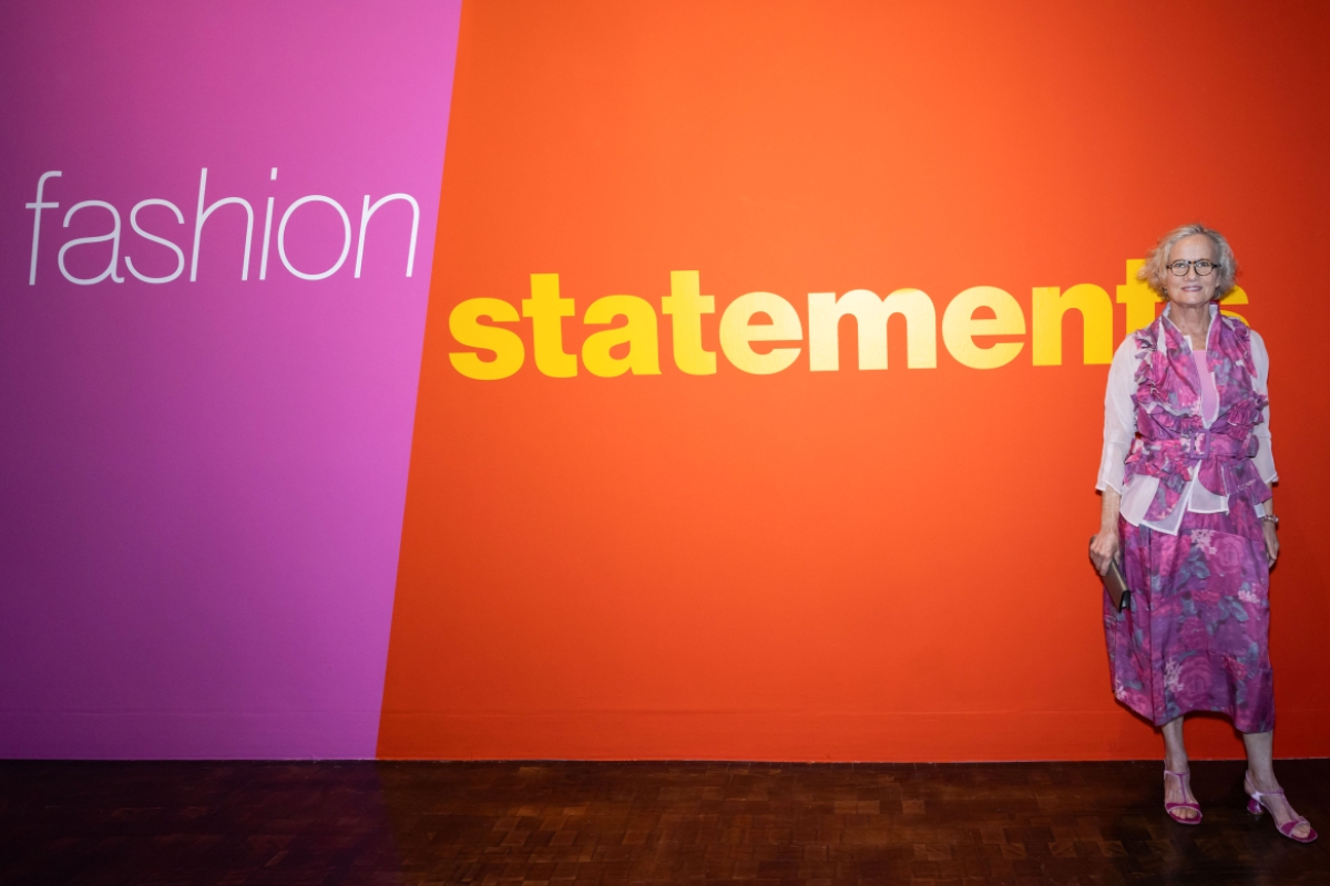 Woman standing in front of a wall with the words 