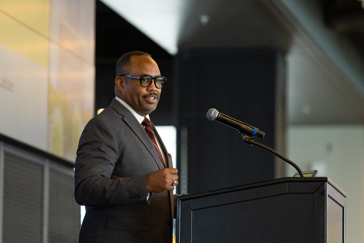 Black man smiles while at a podium