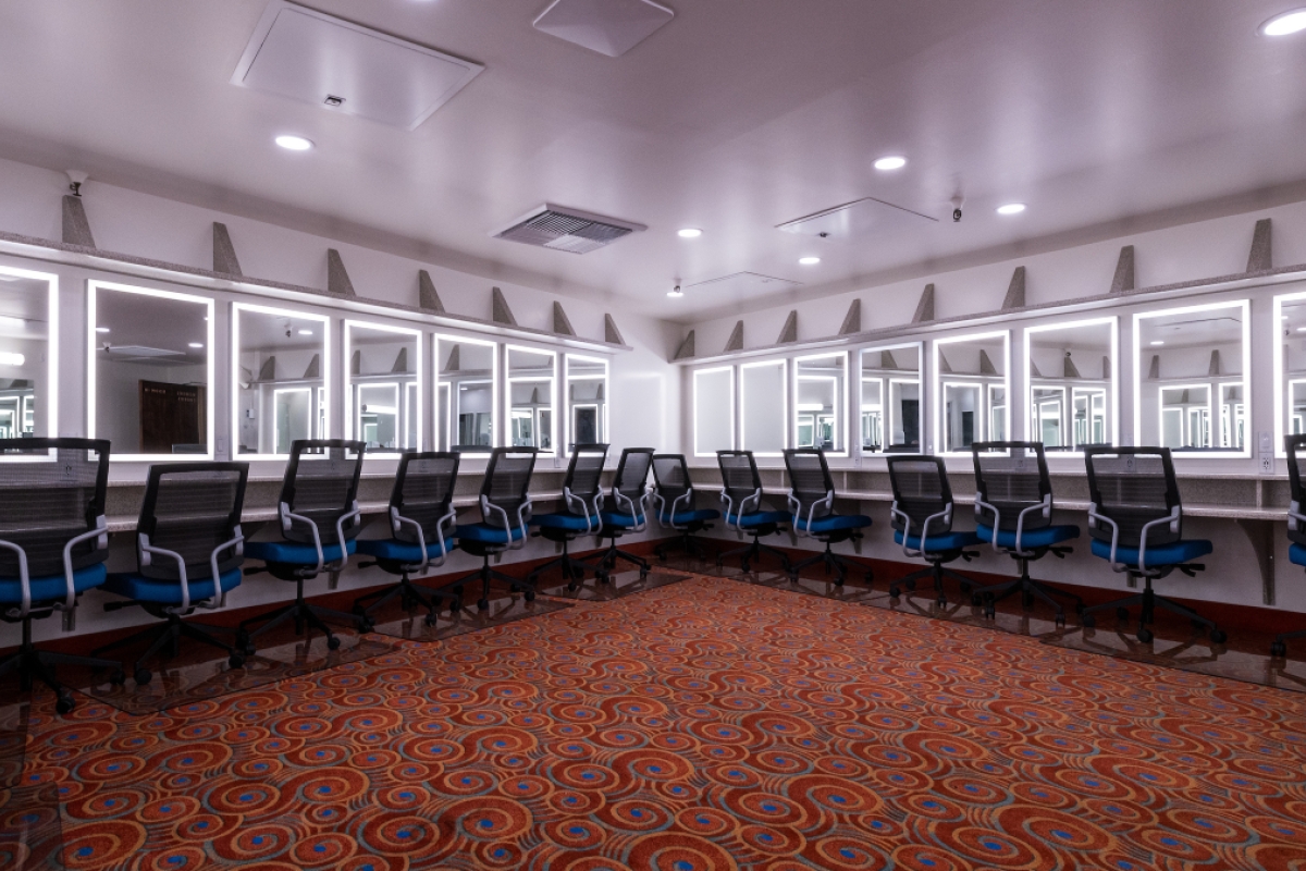 A dressing room with several lighted mirrors