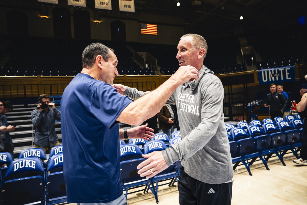 Former Duke basketball coach Mike Krzyzewski and ASU coach Bobby Hurley embrace on basketball court during practice time