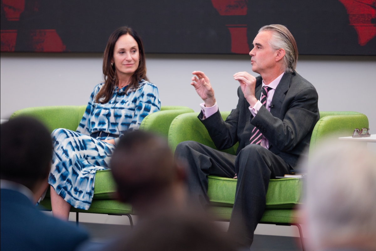 A woman sits next to a man who is speaking 