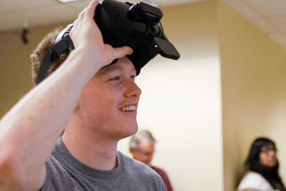 Student smiling while wearing a VR headset.