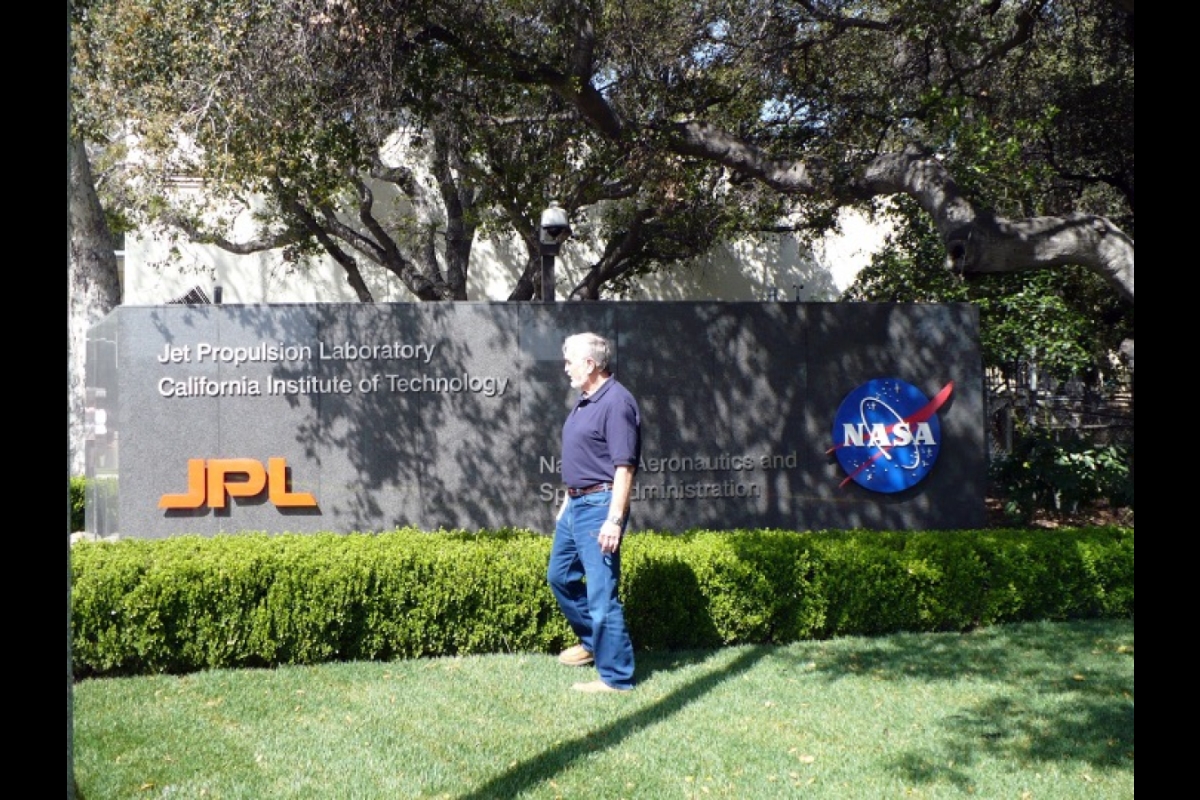 Man standing next to a sign for NASA's Jet Propulsion Laboratory.