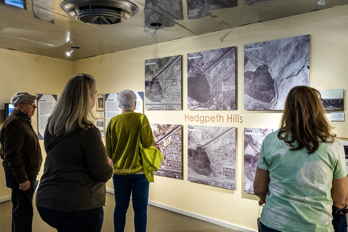 People looking a photo exhibit on the wall