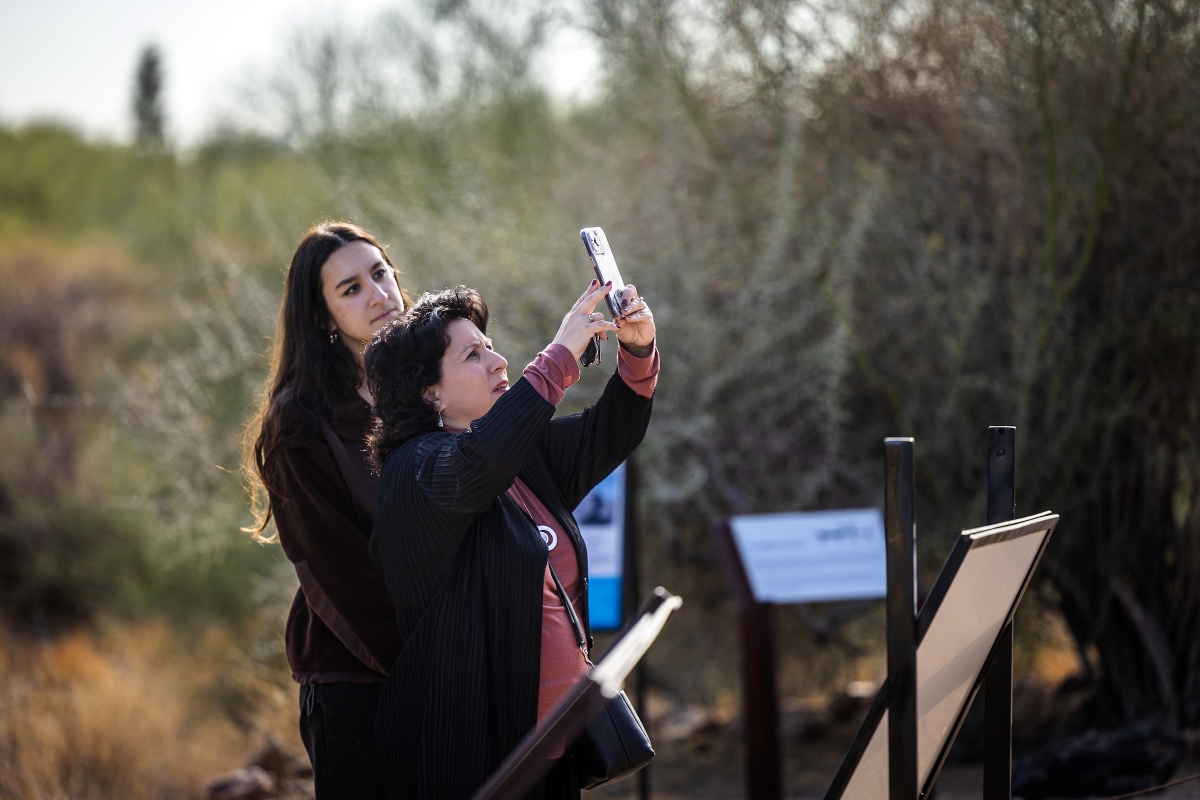 Woman taking a picture of a petroglyph