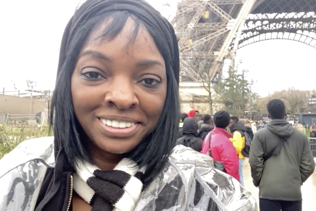 Woman smiling in front the Eiffel Tower.