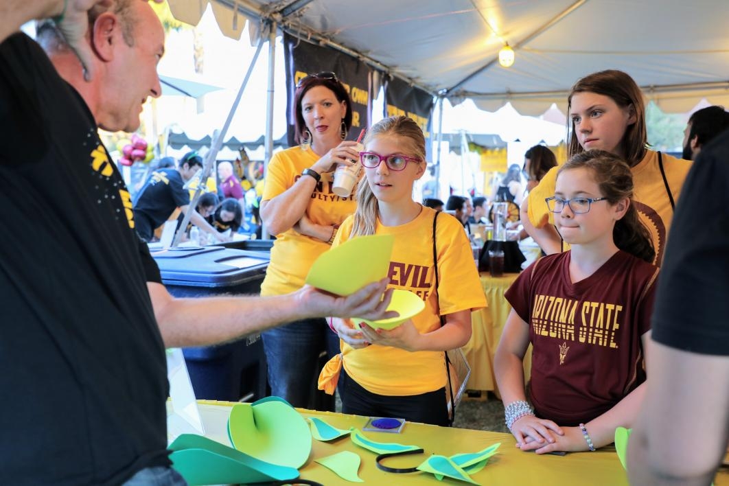 Students and families participate in hands-on science activities at the Biodesign Institute's 2017 homecoming tent\