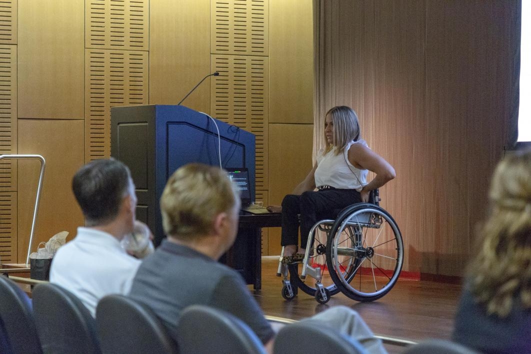 woman in wheelchair on stage speaking to audience