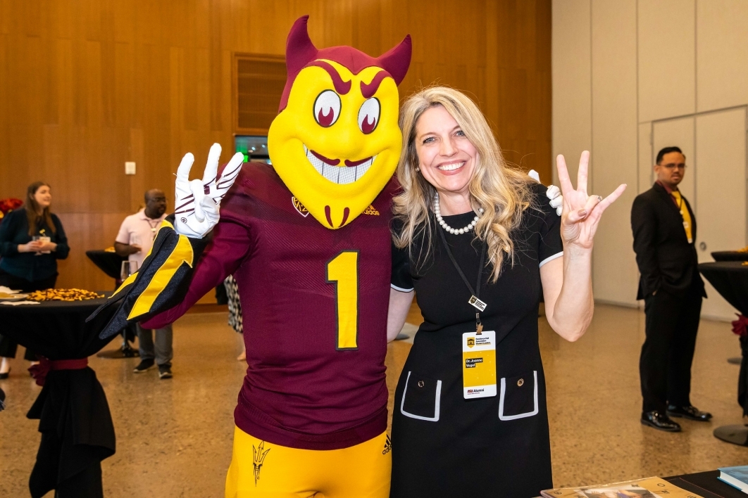 2023 Affinity Reunion goer and Sparky pose with forks up.