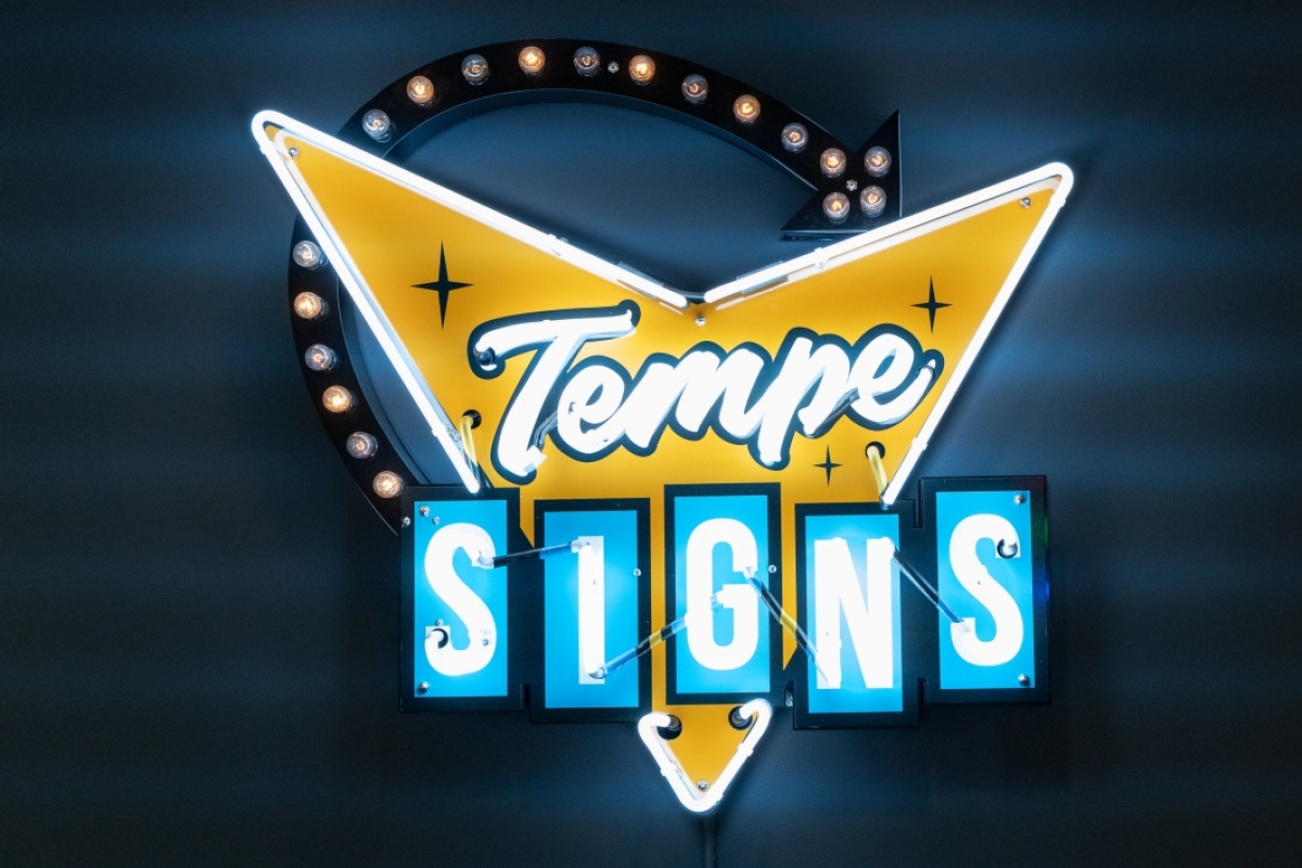 A white, blue and yellow neon sign that reads 